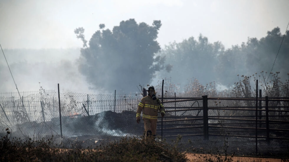Un pompier israélien marche près de la fumée et du feu à la suite de roquettes frontalières lancées vers Israël depuis le Liban, dans le contexte des hostilités transfrontalières en cours entre le Hezbollah et les forces israéliennes, dans le nord d'Israël le 12 juin 2024. REUTERS - Gil Eliyahu